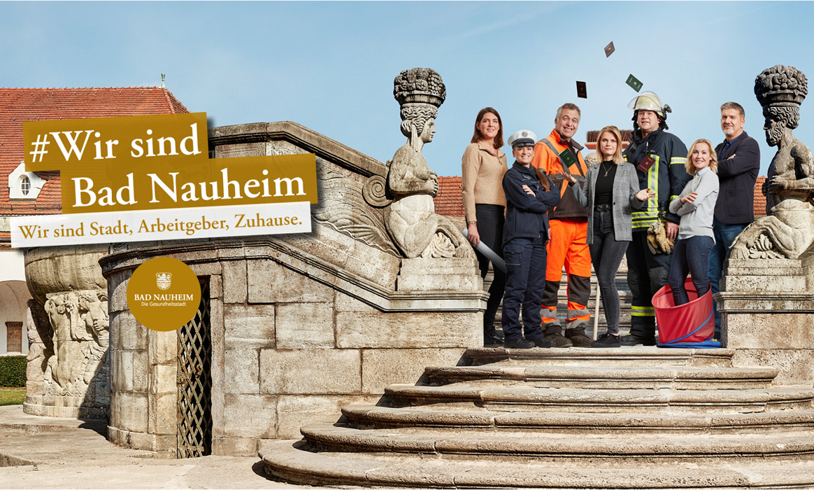 Kampagnenmotiv der Arbeitgebermarke der Stadt Bad Nauheim mit der Überschrift „#Wir sind Bad Nauheim“, dem Claim „Wir sind Stadt. Arbeitgeber. Zuhause.“ sowie einer Gruppe von Mitarbeitenden auf einer historischen Freitreppe.