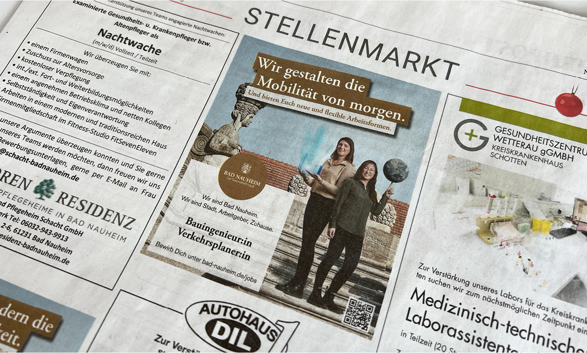 Stellenmarkt-Anzeige der Arbeitgebermarke der Stadt Bad Nauheim in einer Zeitung mit dem Kampagnenmotiv „Wir gestalten die Mobilität von morgen.“ sowie einer Abbildung mehrerer Mitarbeitender.