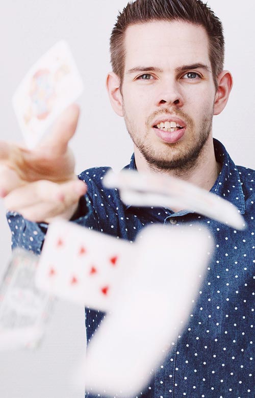 Benjamin Holzhausen wirft Spielkarten in die Kamera