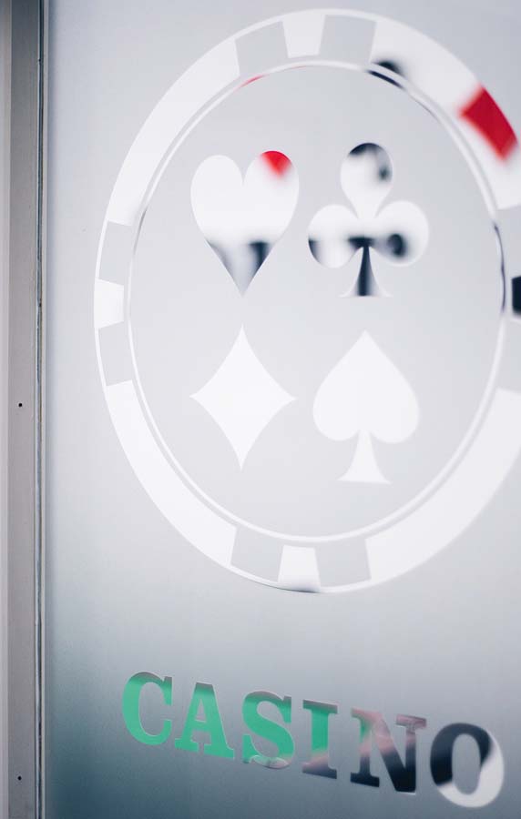 Blick durch Milchglasscheibe mit Poker Chip Symbol und der Aufschritt Casino