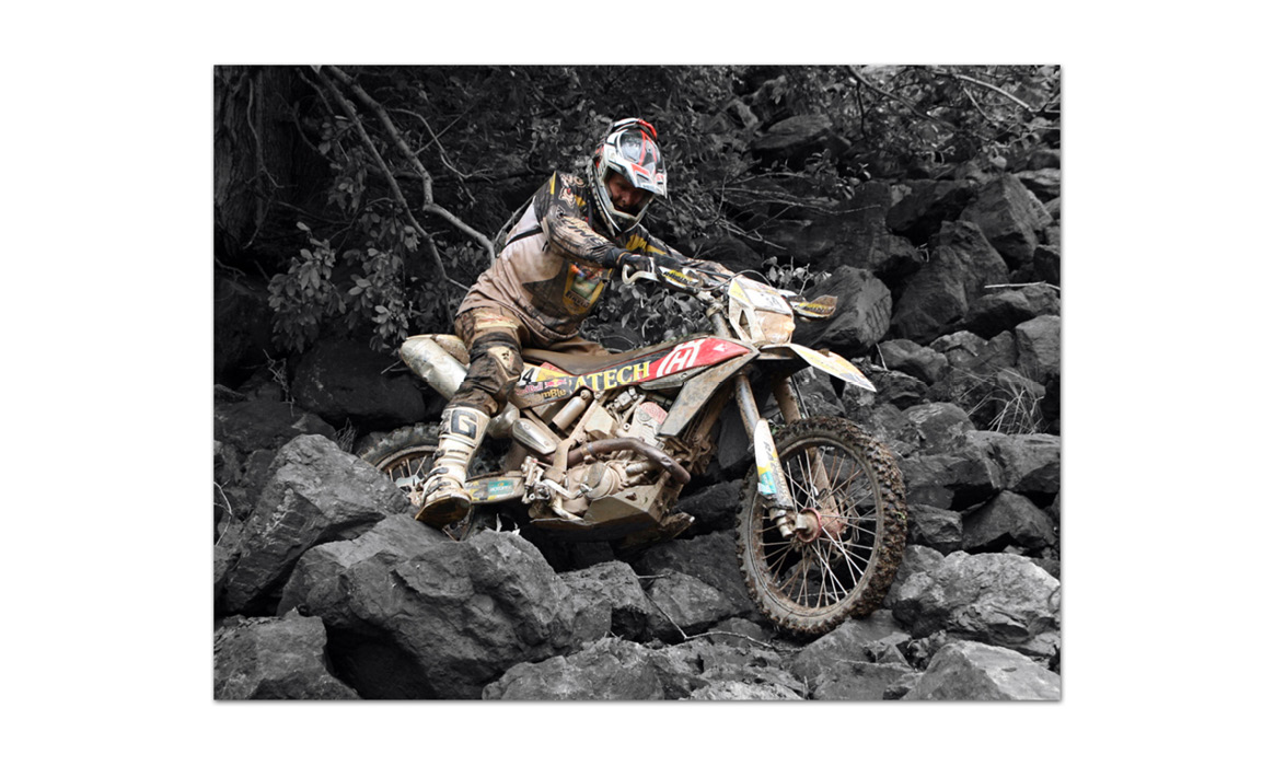 Fotografie eines Endurofahrers auf einem Motorrad im steinigen Gelände mit Marushin-Motorradhelm.