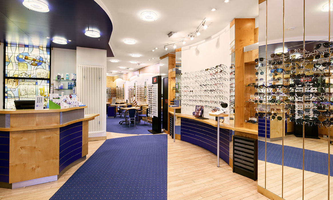 Verkaufsraum von Optik Boelke mit Beratungsbereich, Brillenpräsentationen und ausgestellten Brillenfassungen im Fachgeschäft.