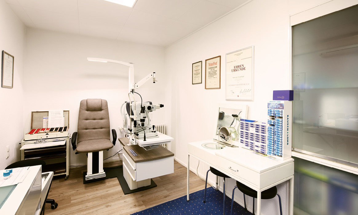Untersuchungsraum von Optik Boelke mit Geräten zur Augenmessung, Behandlungsstuhl und Sehprüftechnik.