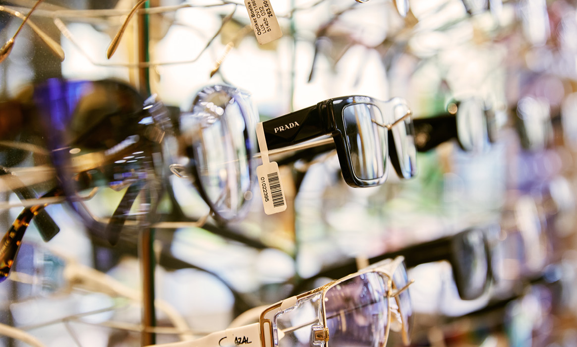 Nahaufnahme mehrerer Brillenfassungen an einer Präsentationswand im Fachgeschäft Optik Boelke.