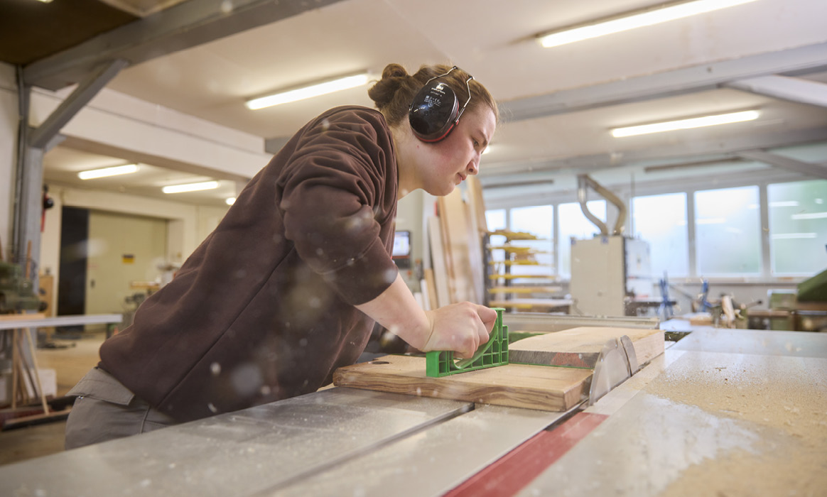Schreiner der Schreinerei Brehm bei der handwerklichen Bearbeitung eines Holzwerkstücks an einer Werkbank.