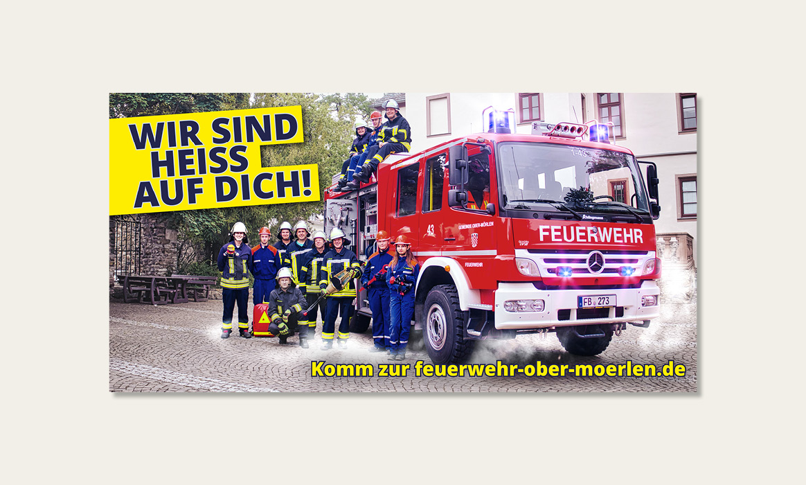 Banner der Freiwilligen Feuerwehr Ober-Mörlen mit dem Slogan „WIR SIND HEISS AUF DICH!“, einem Feuerwehrfahrzeug, Einsatzkräften sowie dem Hinweis „Komm zur feuerwehr-ober-moerlen.de“.