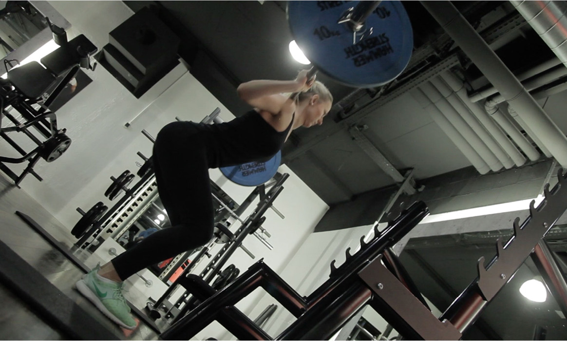 Trainierende Person im Maximum Training & Sportclub während einer Übung an einem Fitnessgerät.